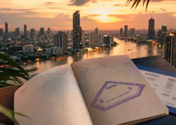 Thailand visa exemption 2026: Bangkok skyline at dusk with Thai flag — covered by Vivre en Thaïlande