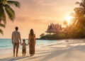 Une famille regarde le coucher de soleil sur une plage thaïlandaise avec un pavillon traditionnel en arrière-plan.