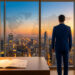Un homme d'affaires en costume regarde un panorama urbain au coucher du soleil avec une carte du monde sur la vitre.