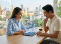 Couple thaïlandais consultant des graphiques sur une tablette avec Bangkok en arrière-plan.