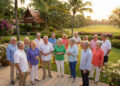 Groupe de retraités souriants discutant dans un jardin tropical luxuriant à Hua Hin lors d'une réception au coucher du soleil.