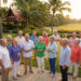 Groupe de retraités souriants discutant dans un jardin tropical luxuriant à Hua Hin lors d'une réception au coucher du soleil.