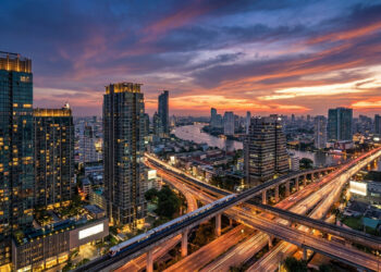 Vue aérienne du coucher de soleil sur les gratte-ciel, le fleuve Chao Phraya et le réseau de transports de Bangkok.