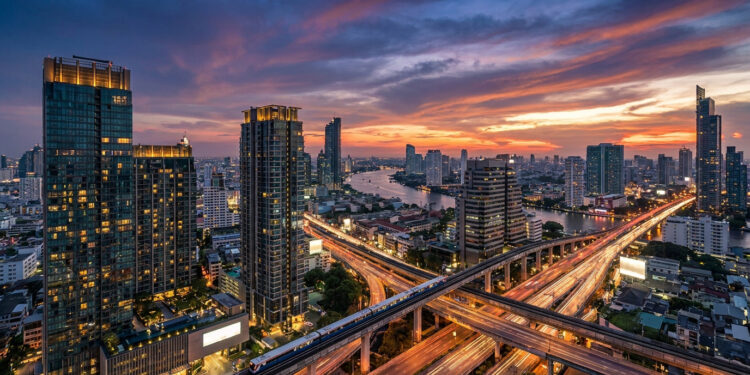 Vue aérienne du coucher de soleil sur les gratte-ciel, le fleuve Chao Phraya et le réseau de transports de Bangkok.