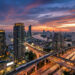 Vue aérienne du coucher de soleil sur les gratte-ciel, le fleuve Chao Phraya et le réseau de transports de Bangkok.