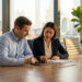 Homme et femme d'affaires collaborant sur une tablette dans un bureau avec vue sur Bangkok.