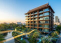 Immeuble résidentiel moderne en Thaïlande avec des graphiques financiers numériques superposés au coucher du soleil.