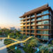 Immeuble résidentiel moderne en Thaïlande avec des graphiques financiers numériques superposés au coucher du soleil.