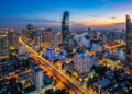 Vue aérienne nocturne spectaculaire des gratte-ciel de Bangkok avec le fleuve Chao Phraya et les lumières de la ville.