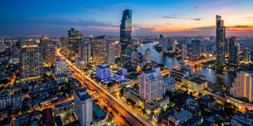 Vue aérienne nocturne spectaculaire des gratte-ciel de Bangkok avec le fleuve Chao Phraya et les lumières de la ville.