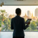 Une femme d'affaires regarde par la fenêtre d'un bureau moderne avec vue sur Bangkok et tient une tablette numérique.