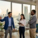 Trois professionnels travaillant ensemble dans un bureau moderne avec vue sur Bangkok.
